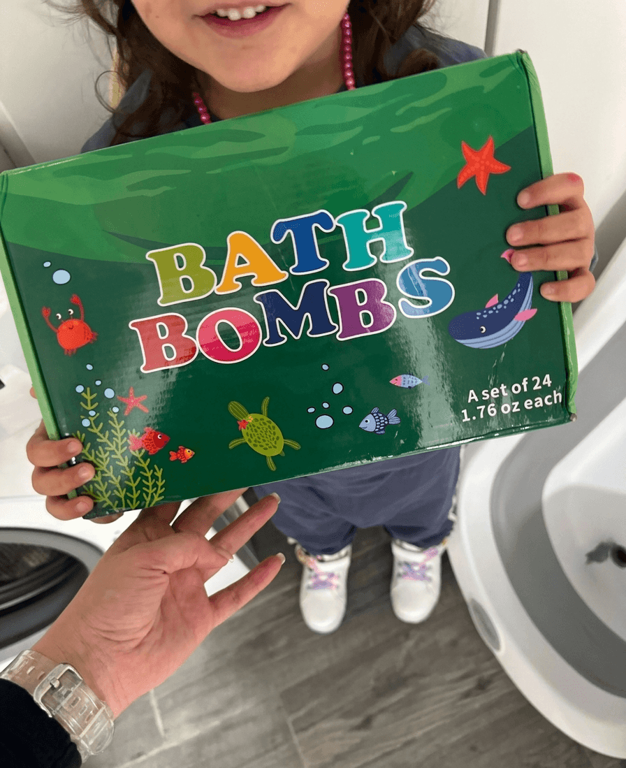 Child holding a box of bath bombs with colorful text and illustrations.
